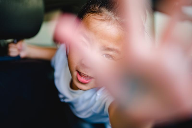 A child holding their hand in front of their face