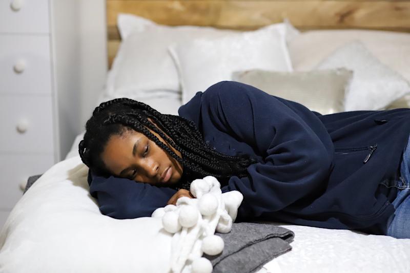 Young woman lies on bed 