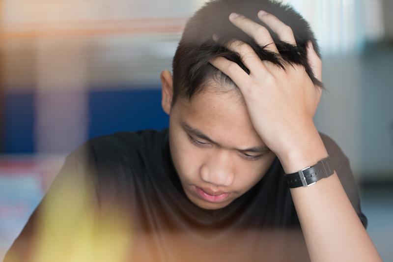 Young boy with his head in his hands